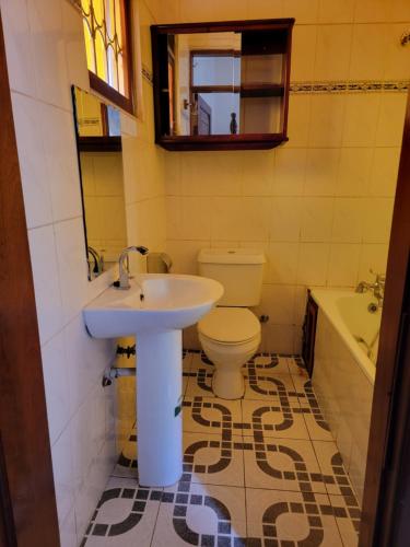 a bathroom with a toilet and a sink at HEDGE GUEST HOUSE in Kampala