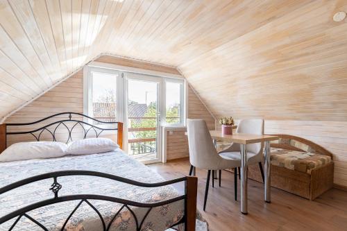 a bedroom with a bed and a table and a window at Kopų 32 Šventoji in Šventoji