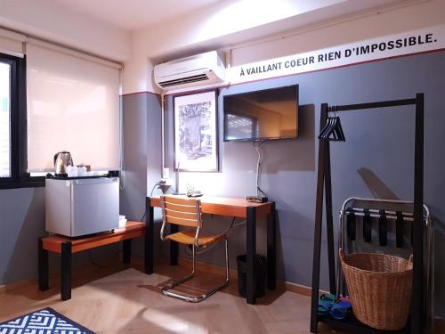 a room with a desk and a table with a lamp at Somewhere to Escape - Hometel in Bangkok