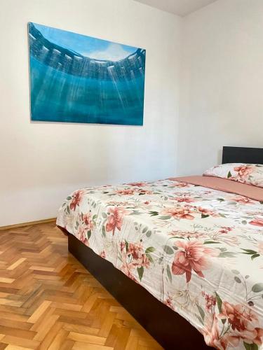 1 cama en un dormitorio con una pintura en la pared en Two Stars Apartment en Podstrana