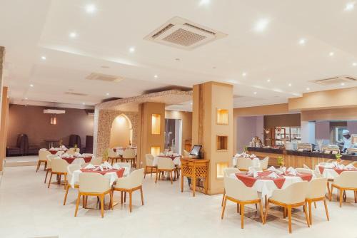 una sala da pranzo con tavoli, sedie e un bar di Tanga Beach Resort & Spa a Tanga