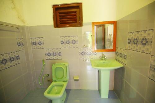 a bathroom with a green toilet and a sink at Casa Ninearch Villa in Ella