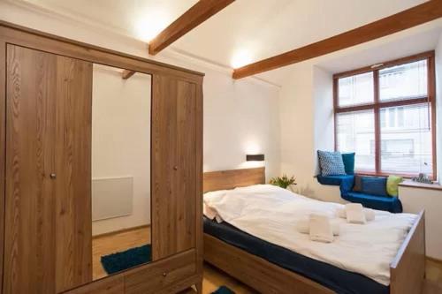 - une chambre avec un lit et deux chaises bleues dans l'établissement Cozy studio on Wielopole street., à Cracovie