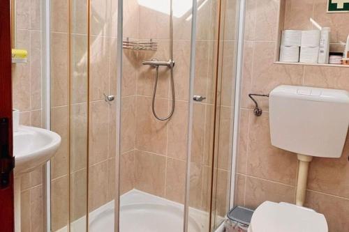 y baño con ducha, aseo y lavamanos. en Moradia na Serra en Alcanede
