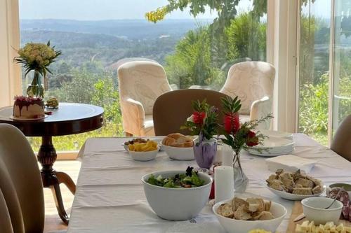 a table with bowls of food on it with a view at Moradia na Serra in Alcanede