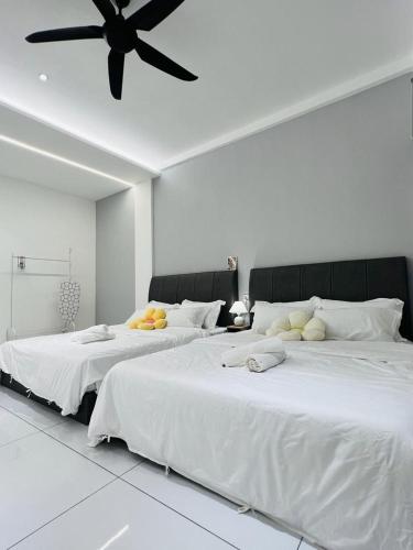Cette chambre blanche dispose de 2 lits et d'un ventilateur de plafond. dans l'établissement Inn Homestay Cozy Room 1st Floor, à Teluk Intan