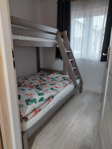 a bunk bed in a room with a bedsheet at Domki Letniskowe Family Dreams in Sarbinowo