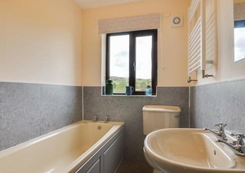 een badkamer met een bad, een wastafel en een toilet bij Providence Mill in Hawes