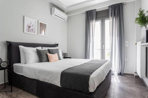 een slaapkamer met een groot bed en een groot raam bij Sublime 1BR Apartment in Koukaki by UPSTREET in Athene