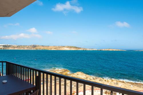 a view of the ocean from a balcony at Islet Promenade Seafront 1 Bedroom Apartment with sea view balcony by Getawaysmalta in St. Paul's Bay