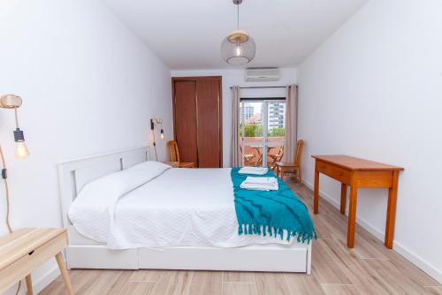Habitación blanca con cama y escritorio en A50 - Castelos Apartment in Portimão, en Portimão