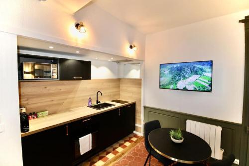 une cuisine avec une table, un évier et un comptoir dans l'établissement Les Bons Enfants - Vieux Marché Rouen 4P Wifi, à Rouen