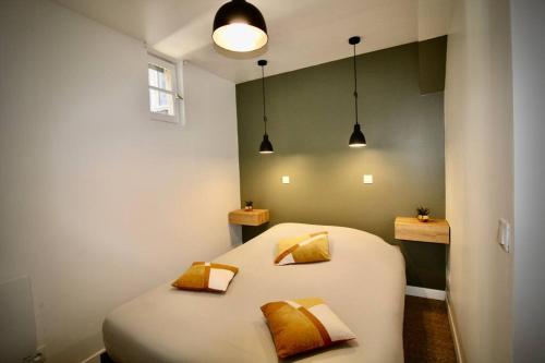 une chambre avec un grand lit blanc avec deux oreillers dans l'établissement Les Bons Enfants - Vieux Marché Rouen 4P Wifi, à Rouen