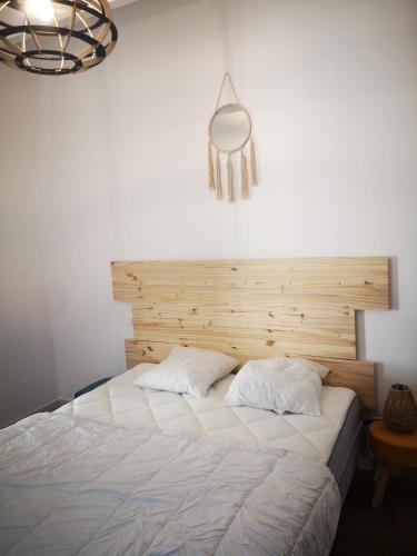 une chambre avec un grand lit avec une tête de lit en bois dans l'établissement Maisonnette 4 pers rez de jardin avec terrasse, au Cap d'Agde