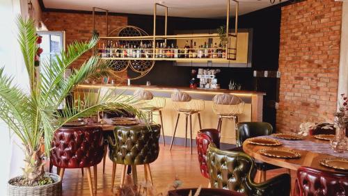 a restaurant with tables and chairs and a bar at Villa Westfalia Guest House in Tîrgu Secuiesc