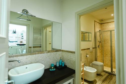 a bathroom with a sink and a toilet and a mirror at TERESITA WELLNESS CLUB in Viareggio