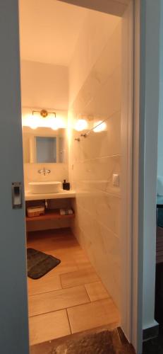 a bathroom with a sink and a tub and a mirror at Enalia Studio in Korissia