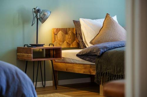 a bed with a wooden bench with a night stand at Heart of Interlaken Apartments in Interlaken