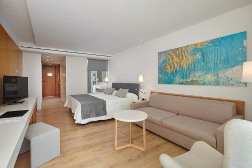 a living room with a bed and a couch at Hipotels Playa de Palma Palace&Spa in Playa de Palma