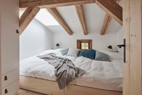 a bedroom with a bed with white sheets and blue pillows at Alpeltalhütte in Schönau am Königssee