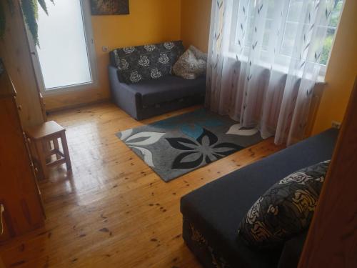 uma sala de estar com um sofá e uma cadeira em Apartament u Wuja morze/plaża/ogród/parking em Gdansk