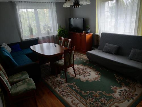 uma sala de estar com uma mesa e um sofá em Apartament u Wuja morze/plaża/ogród/parking em Gdansk