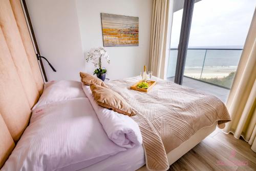 sypialnia z łóżkiem i widokiem na ocean w obiekcie Your Holidays Waves A865 w mieście Międzyzdroje