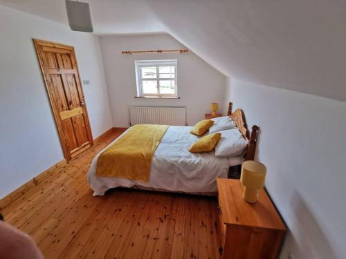 Schlafzimmer mit einem Bett und Holzboden in der Unterkunft Cozy 6 Bedroom house with spectacular views in Belmullet