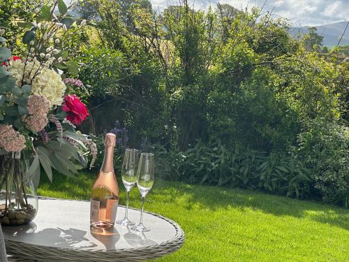 a bottle of wine and two wine glasses on a table at Ann's Hill in Cockermouth