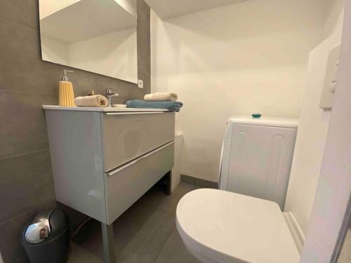 une salle de bain avec des toilettes blanches et un lavabo dans l'établissement L'Orangeraie Centre Cannes Martinez, Beau F2 avec terrasse, à Cannes