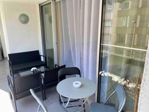 een balkon met een tafel en stoelen en een raam bij Centre Cannes Martinez, Beau F2 avec terrasse in Cannes