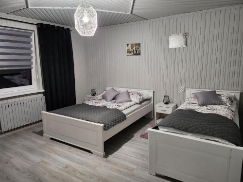 1 Schlafzimmer mit 2 Betten und einem Kronleuchter in der Unterkunft Apartament u Irenki in Harklowa