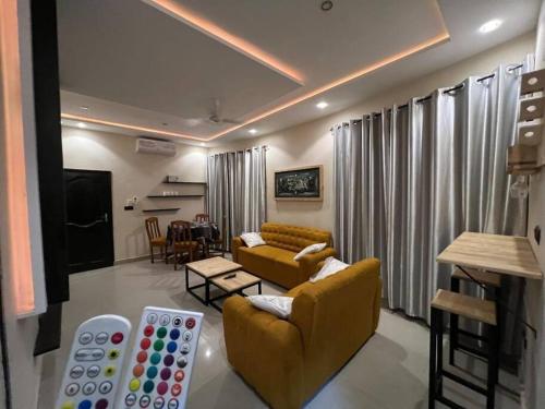a living room with two yellow couches and a table at MonGite in Cotonou