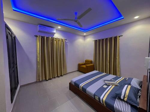 - une chambre avec un lit et un plafond bleu dans l'établissement MonGite, à Cotonou