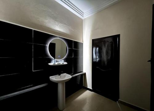 a bathroom with a sink and a mirror on the wall at MonGite in Cotonou