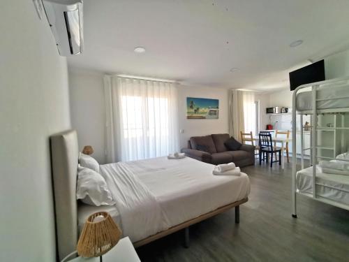 a bedroom with a bed and a living room at Vila Alexandra in Costa da Caparica
