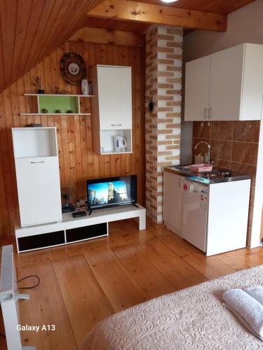 een keuken met witte kasten en een tv. bij Apartman Andrija in Žabljak