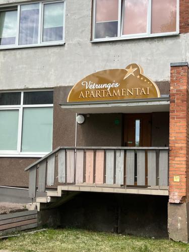 un edificio con un cartello che leggeva "Readsarmaarmaarmaarmaental" di Vėtrungės Apartamentai a Klaipėda