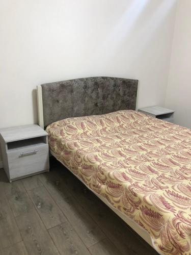 a bed in a room with two nightstands next to a bed sidx sidx at Апартаменты «Четыре сезона» in Sukhum