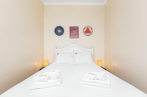 1 dormitorio con 1 cama blanca y 2 toallas en Hopstays Oporto Dragão - 120 m from São Roque Park, en Oporto