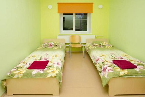 Haapsalu Kutsehariduskeskuse hostel في هابسالو: غرفة بسريرين وطاولة ونافذة