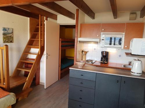 une petite cuisine avec un escalier menant à un lit superposé dans l'établissement Font-Romeu Appart T2 + Cabine - Vue panoramique, à Font-Romeu-Odeillo-Via