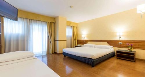a hotel room with two beds and a window at Best Western Hotel I Colli in Macerata