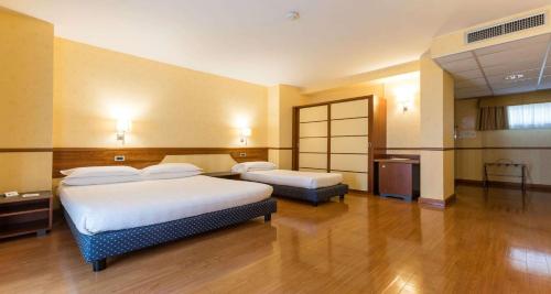a hotel room with two beds and a television at Best Western Hotel I Colli in Macerata