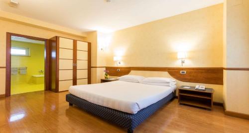 a bedroom with a large bed and a bathroom at Best Western Hotel I Colli in Macerata