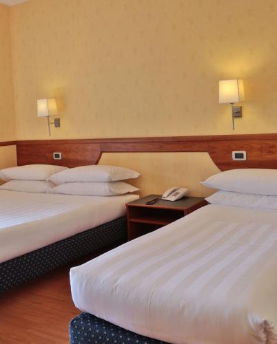 a hotel room with two beds and a phone on a table at Best Western Hotel I Colli in Macerata
