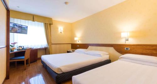 a hotel room with two beds and a desk at Best Western Hotel I Colli in Macerata