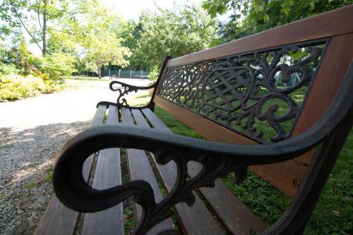 a wooden bench sitting in a park at Napvirág-Ház in Zsira
