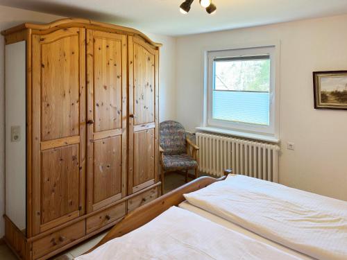 - une chambre avec une armoire en bois et un lit dans l'établissement Haus *Üüs Aran* Wohnung Nr. 1, à Nebel