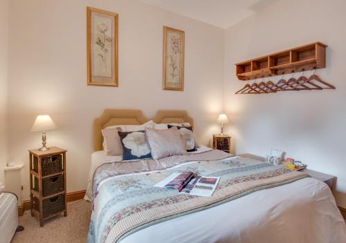 a bedroom with a large bed and two lamps at Piglet Cottage in Seamer